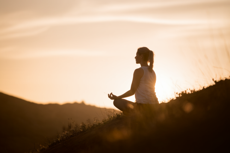 silhouette-meditant-colline-soleil-couchant